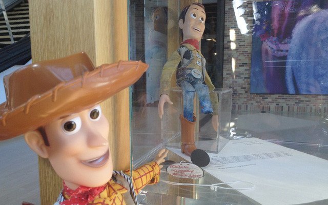 La poupée Woody aux Studios Pixar. Une étiquette au nom de Caleb est accrochée à sa botte.