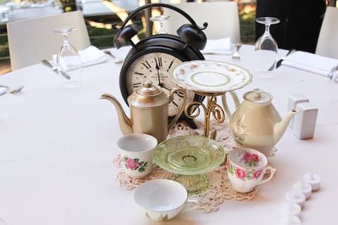 Table consacrée à Alice au Pays des Merveilles, avec des tasses de thé et une pendule
