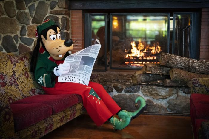 Noël fête noël à la maison en lisant le journal devant la cheminée
