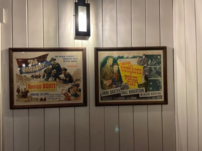 Deux affiches de films Disney accrochées au mur, illustrant les secrets et l'histoire du Disney Hotel Cheyenne.