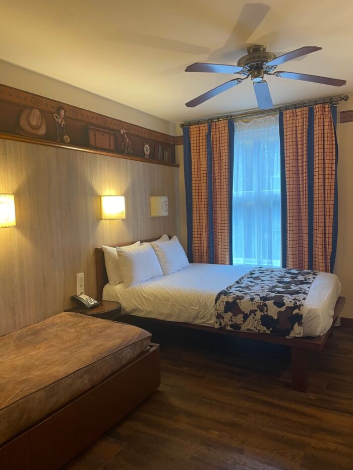 Une chambre confortable au Disney Hotel Cheyenne dotée d'un lit confortable et d'une table de chevet pratique.