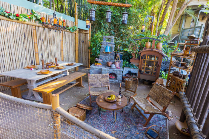 Une terrasse en bois avec une table et des chaises Robinson.