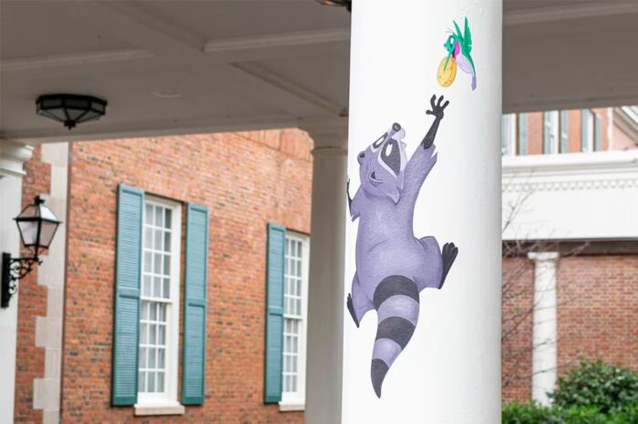 Un raton laveur de bande dessinée est peint sur une colonne devant un bâtiment d'EPCOT.