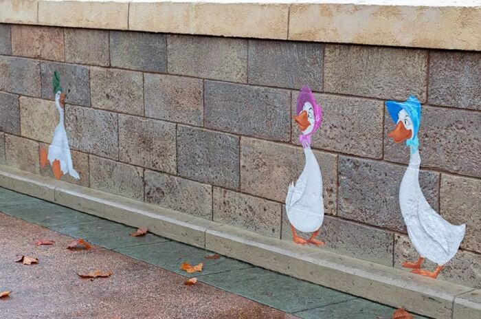 Une collection de canards peints sur le côté d'un mur en EPCOT.