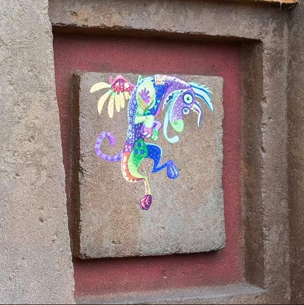 Une peinture colorée d’un dragon sur un mur de pierre.
