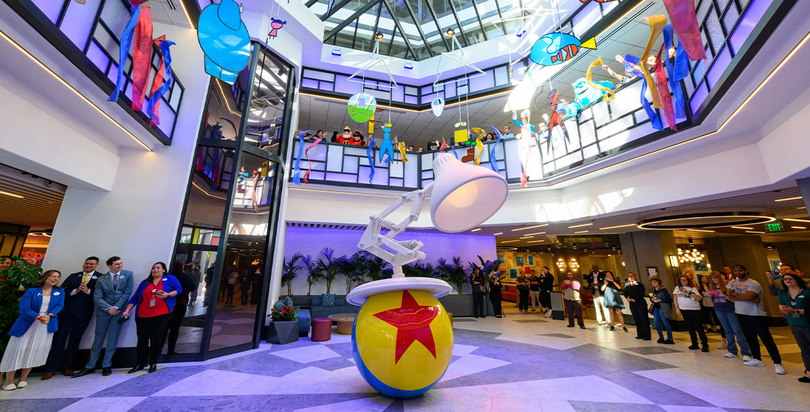 Un groupe de personnes se tient à Pixar Place, un centre commercial.
