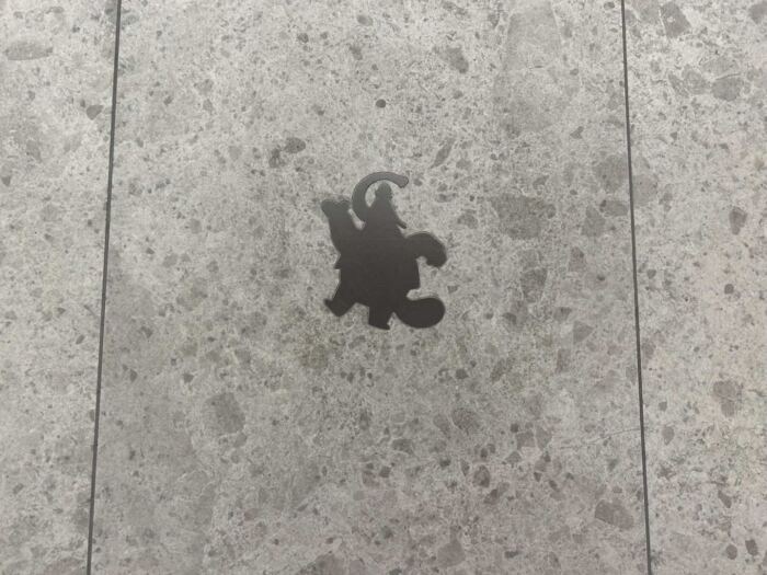 Une silhouette d'un personnage de dessin animé sur un sol en béton à Pixar Place.