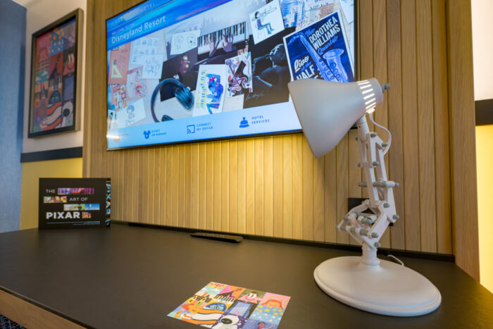 Un bureau avec une lampe et une télévision dans l'hôtel Pixar Place.