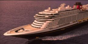 Un navire de Disney Cruise Line, le Disney Destiny, naviguant au coucher du soleil.