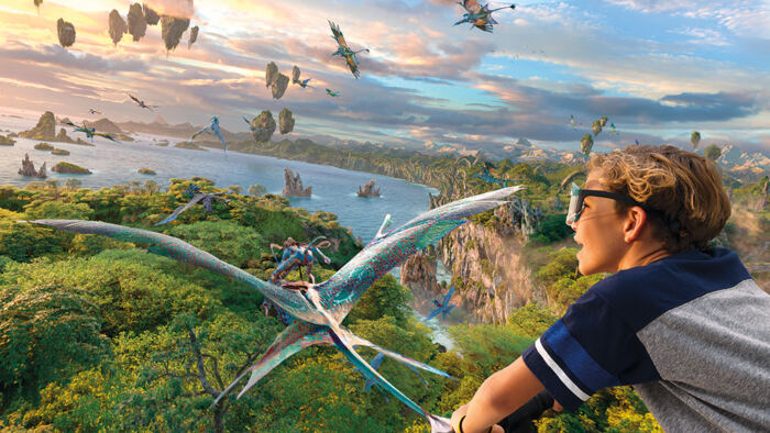 Une personne portant des lunettes fait l'expérience d'une simulation de réalité virtuelle où elle vole parmi des créatures ailées exotiques au-dessus du paysage fantastique de Pandora - Le monde d'Avatar au Walt Disney World Resort.